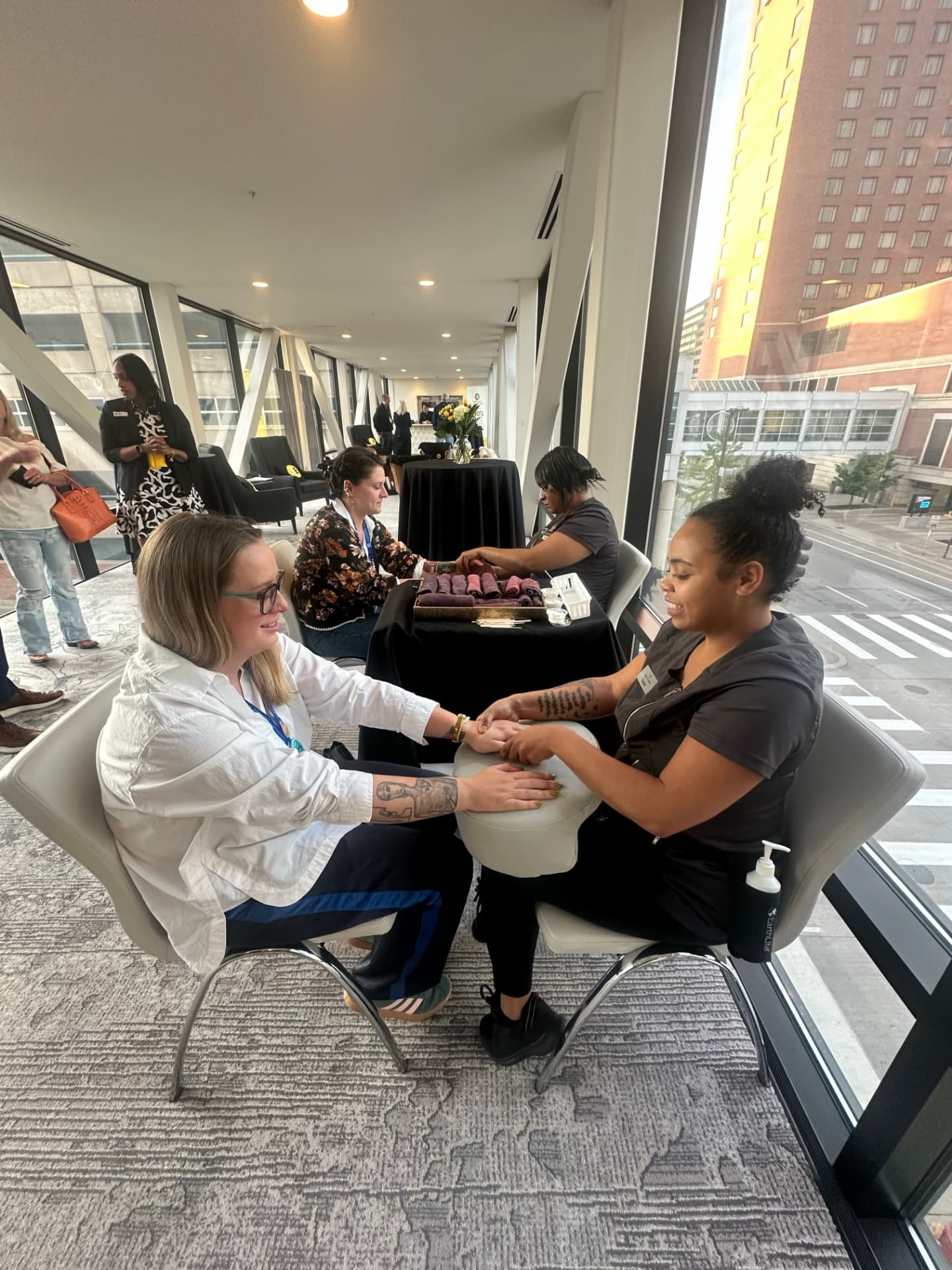 Guests receiving complimentary hand massages from spa practitioners at stations along the Hotel Ivy skyway